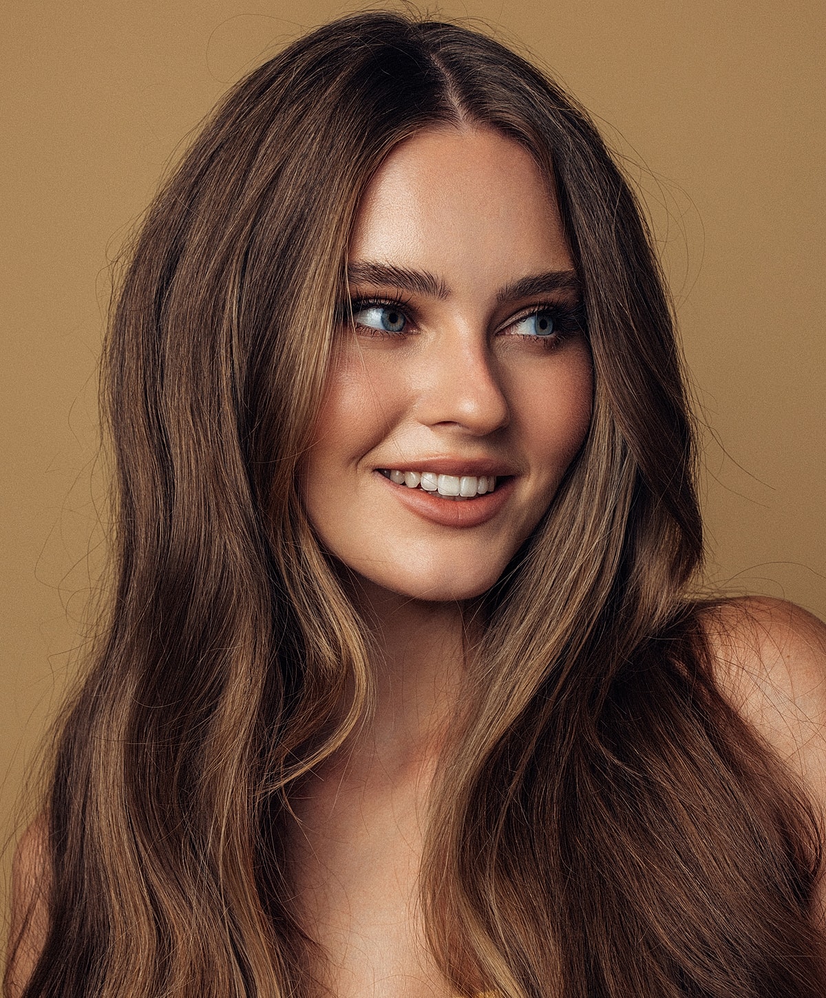 Smiling woman with long, wavy hair.