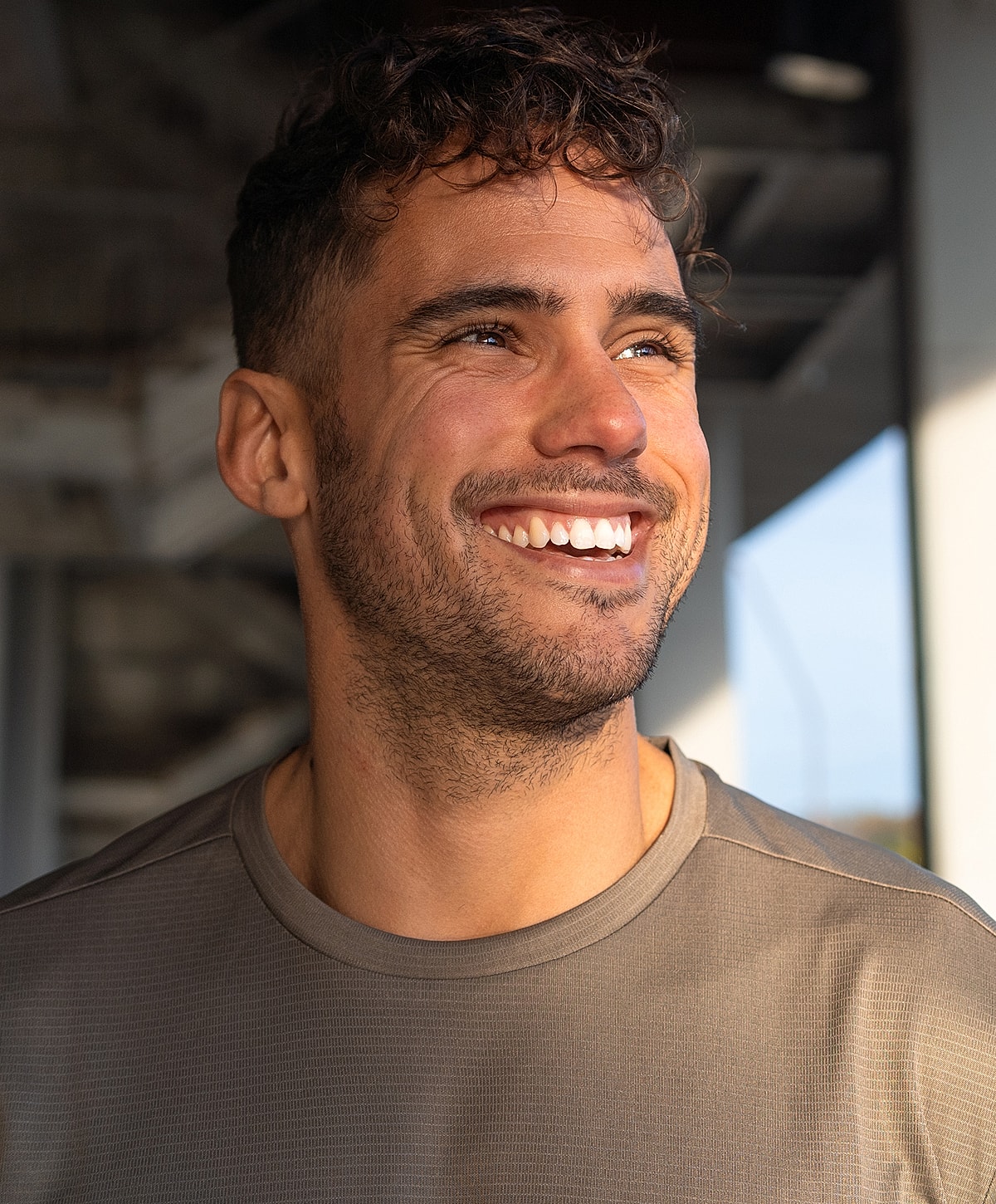 Smiling man wearing a gray athletic shirt.