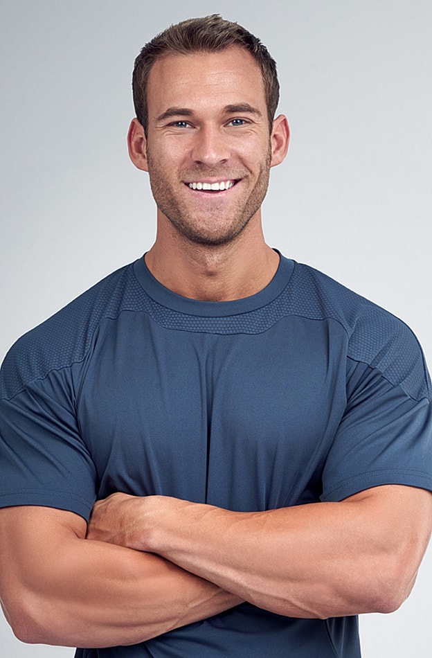 Smiling man with arms crossed in athletic shirt