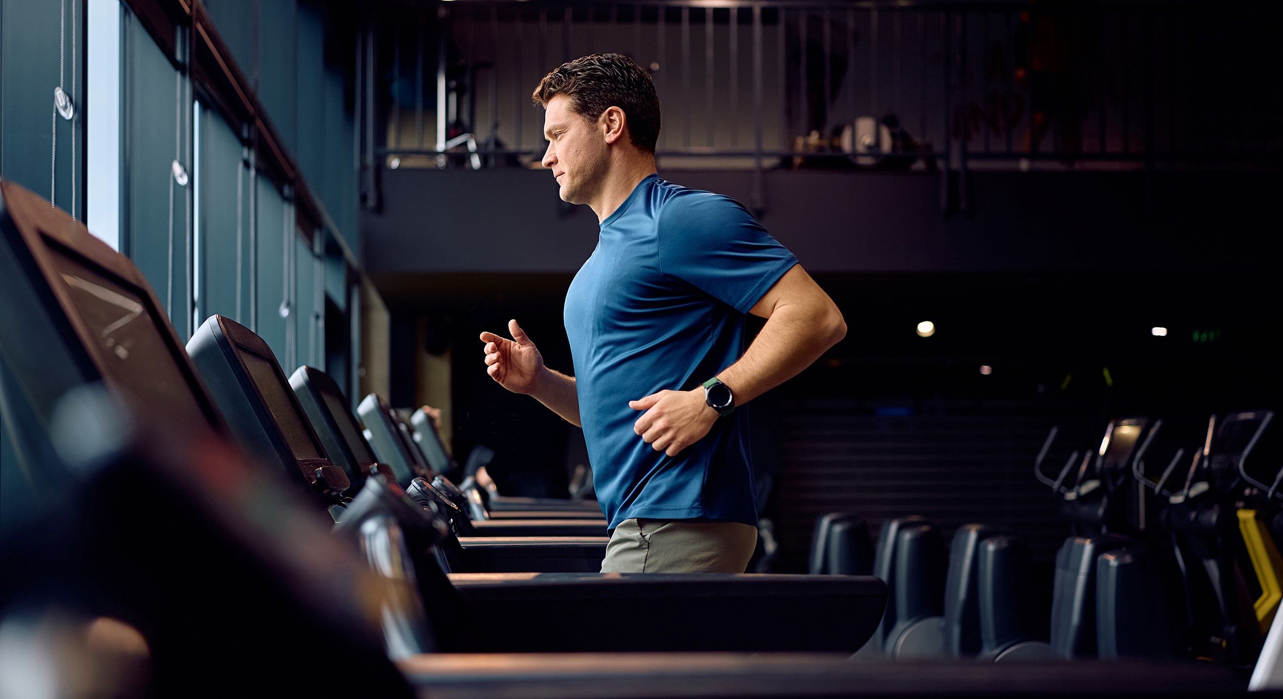 Man jogging on a treadmill in gym.